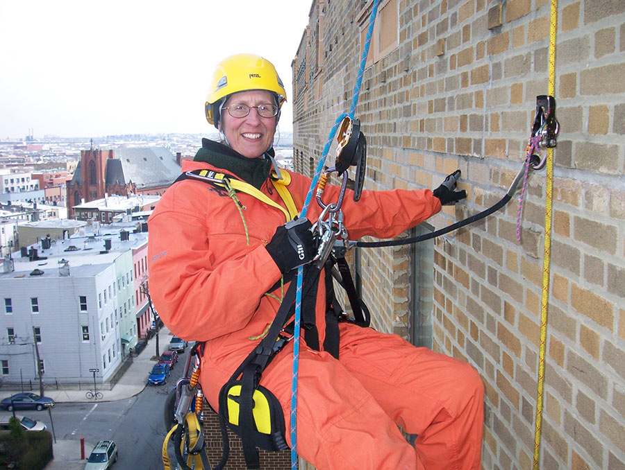 Helen Watts harnessed and hanging against a high rise building