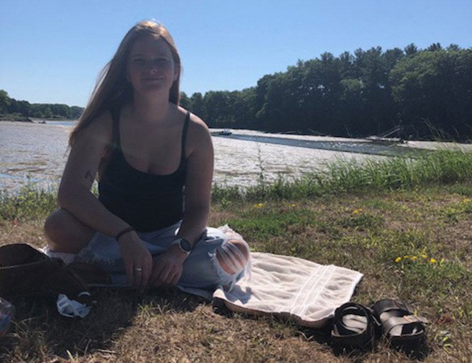 Emily Villenueve sitting near a river in Durham