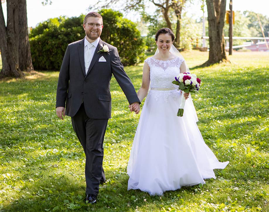 Angela and Joel Graham walking hand in hand on their wedding day