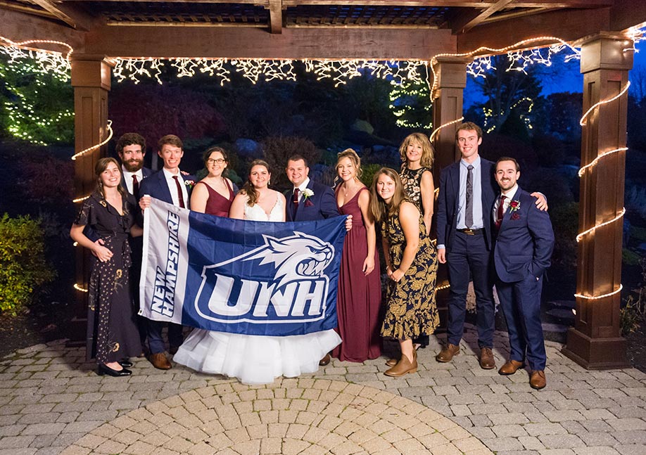 Jordan Miller and Daniel Cohen standing with UNH friends at their wedding