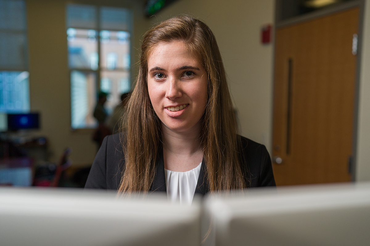 Sarah Blampied ’22 in black suit jacket smiling in student center