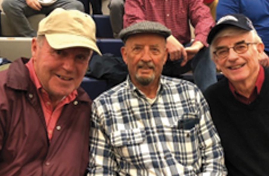 three older men lean in together for a photo at an event