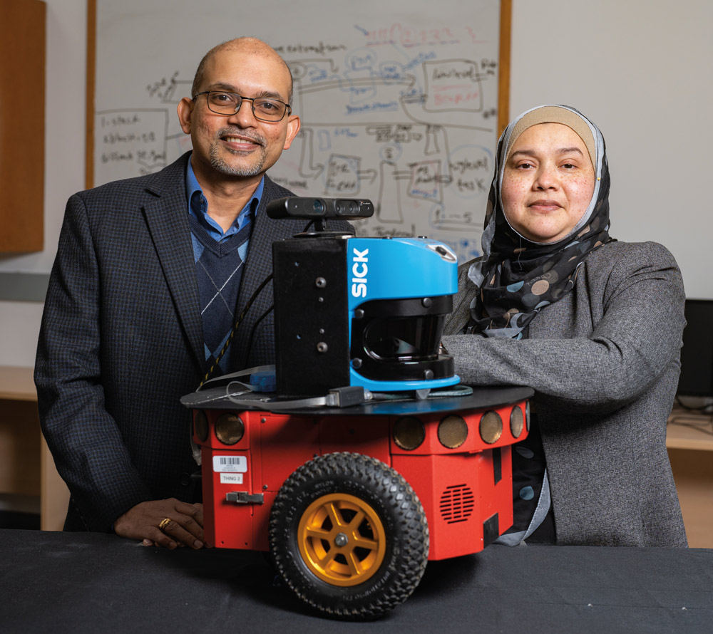 Sajay and Momotaz standing next to robot prototype