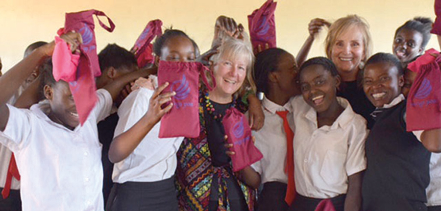 Sharon Runge , center, and Lindsey Burns posing with children in Kenya
