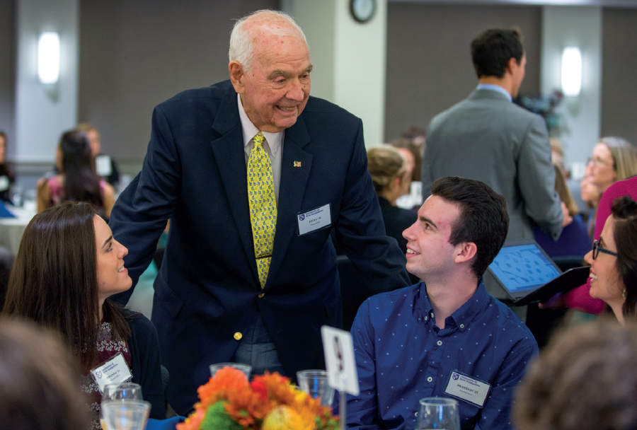 Hamel speaking with students at table during Hamel Scholars luncheon