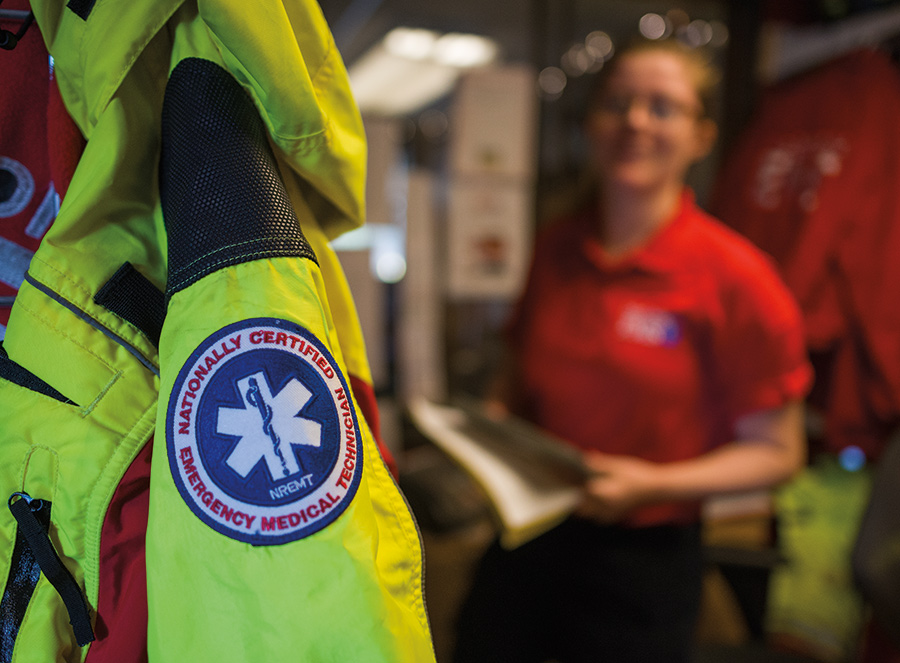 Nationally Certified Emergency Medical Technicians jacket with an EMT standing in the background