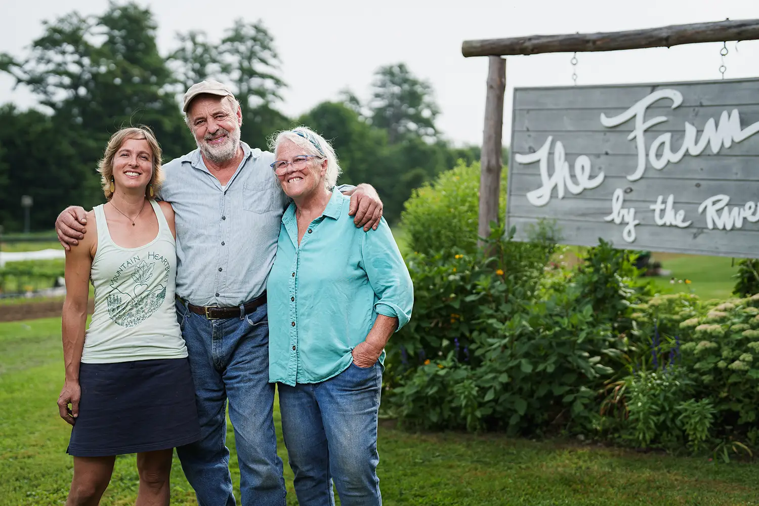 Bill and Eve Klotz with Joanne Ducas posing in front of farm sign