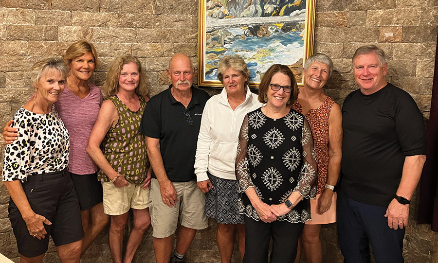 Landscape photograph of (left to right: Caryl Dow ’80, Jennifer Roussel Porter ’81, Lisa Doty Cloyd ’79, David E. Schricker ’74, Carol Constantineau Schricker ’78, Karen MacDonald ’95, Lin Tamulonis ’75 and ’94G and Karen’s husband Don Anderson ’00G at a hotel in Starigrad, Croatia) as they all are smiling in casual relaxed attire
