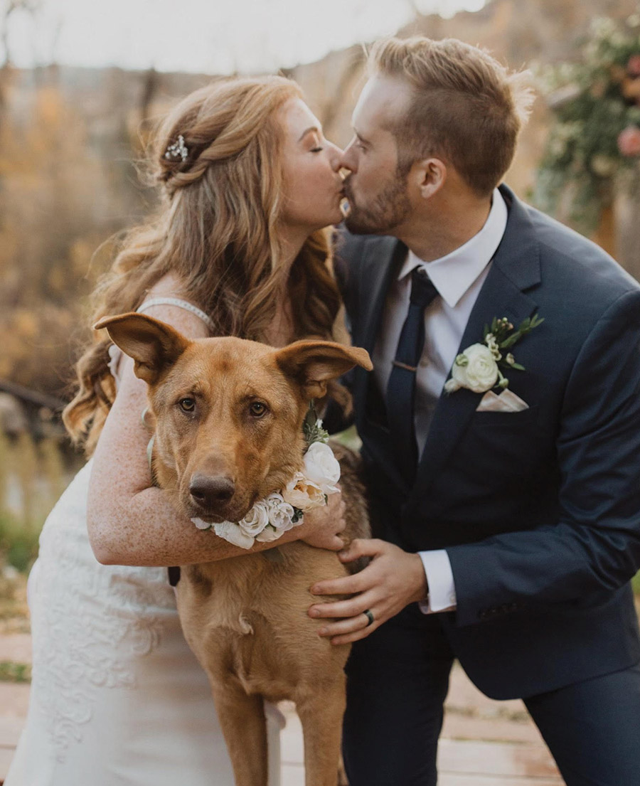 Close-up portrait photograph of Jonathan Tomer ’12, environmental science major and avid UNH men’s Ultimate Frisbee player, kissing Kathleen Dobell in appropriate wedding attire as they married on October 22, 2022, in Steamboat Springs, Colorado; The couple, along with their puppy Moose, live in Waltham, Massachusetts.