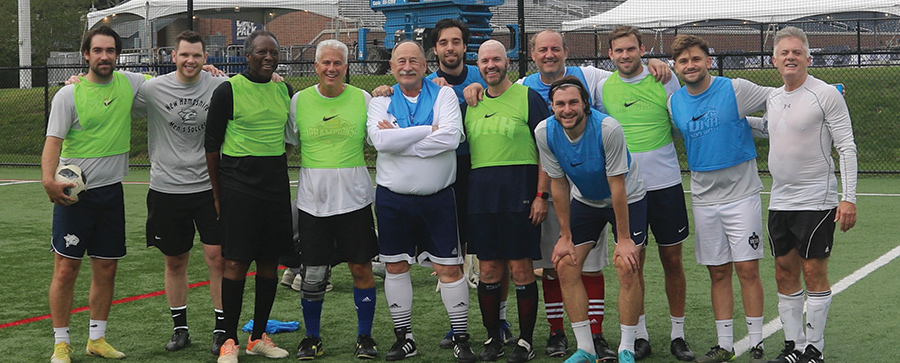 Landscape photograph of a group of 1976 classmates and alumni from various years played in a soccer game as part of a weekend back on campus last fall