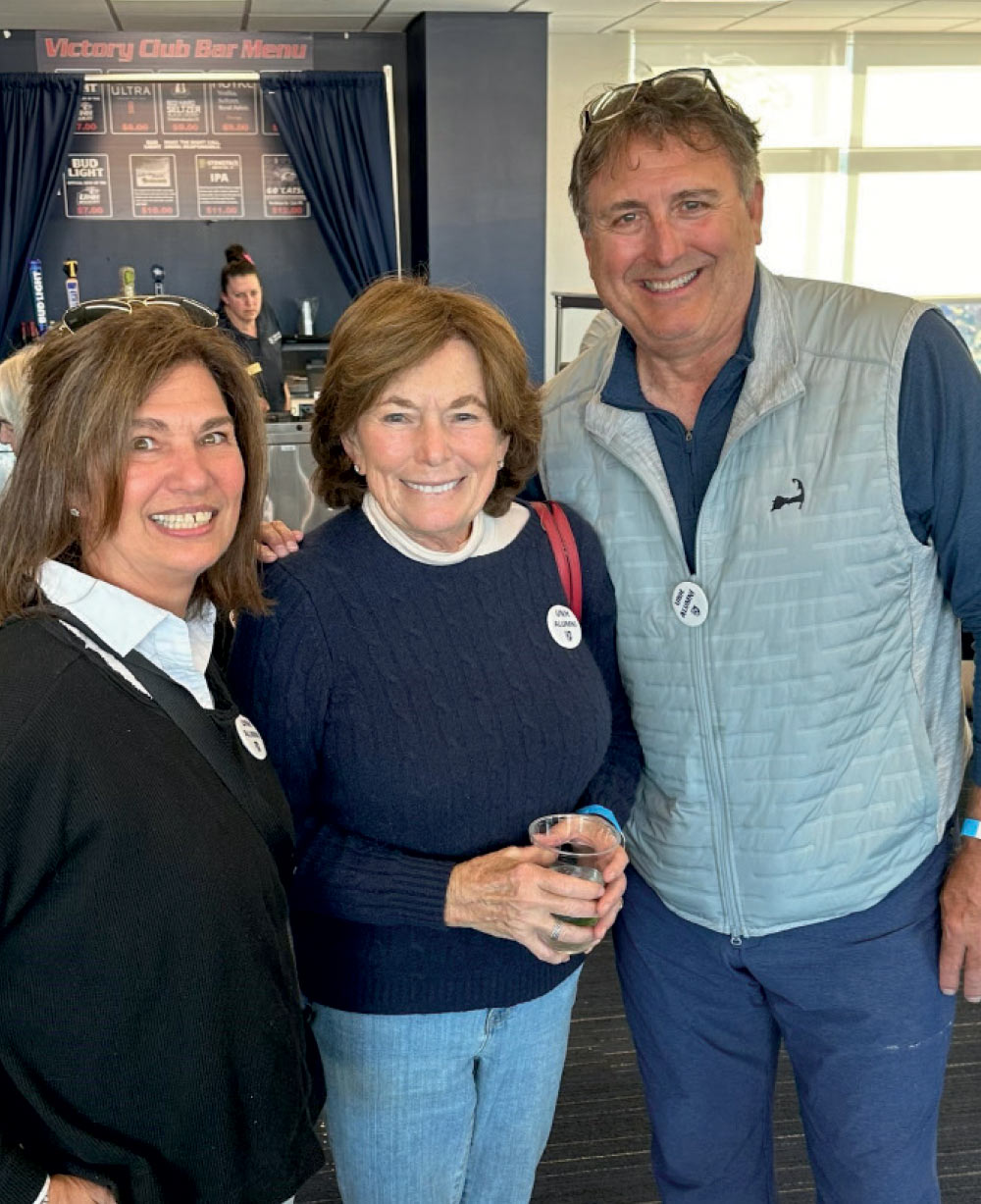 Doug Romano ’81, wife Joan and Natalie Salatich Jacobson ’65, former Boston news anchor, at UNH football game, fall 2024.