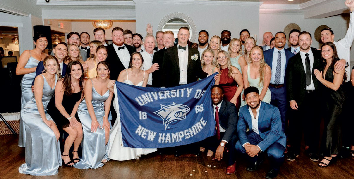 wedding party holding UNH banner