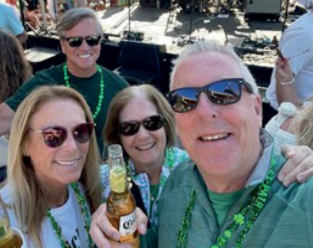 A selfie-style photo shows four people smiling at the camera