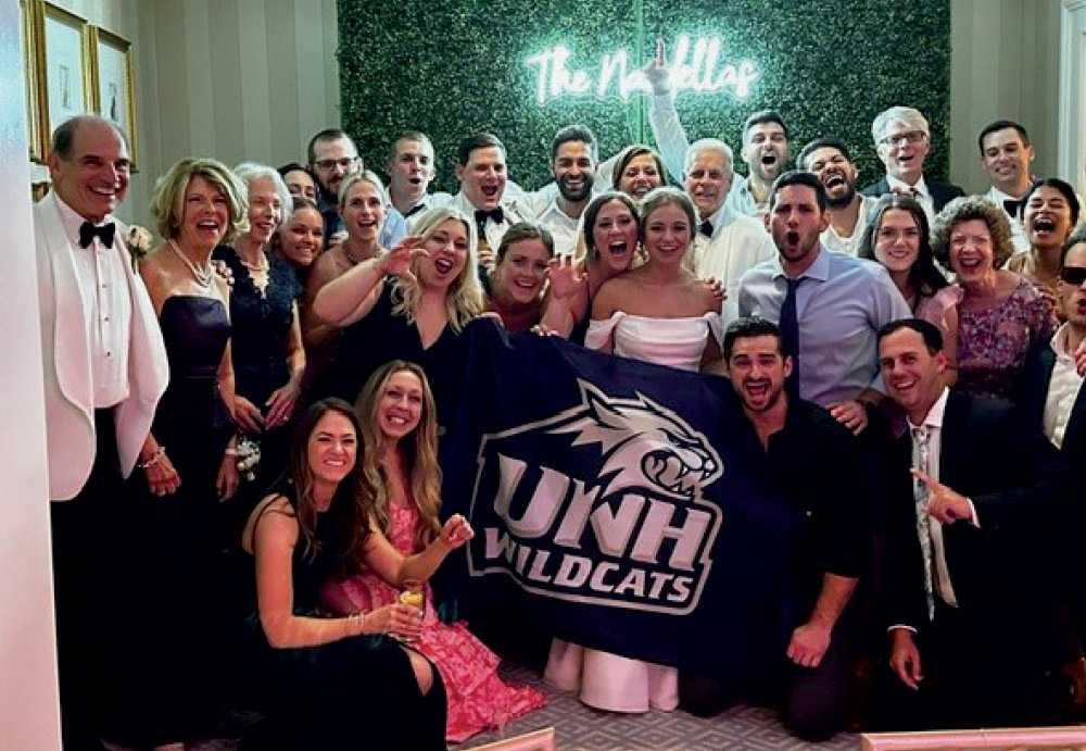 wedding party of Sarah Buckley ’15 and David Nardella ’15 holding a UNH banner