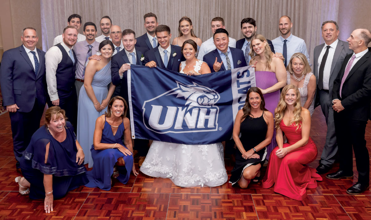 people holding UNH banner at wedding of Brett Pearson and Emily Dion