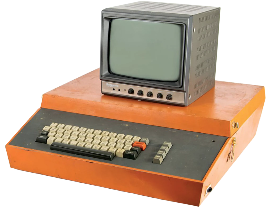 Vintage personal computer with an orange console base, keyboard, and small CRT monitor on top.