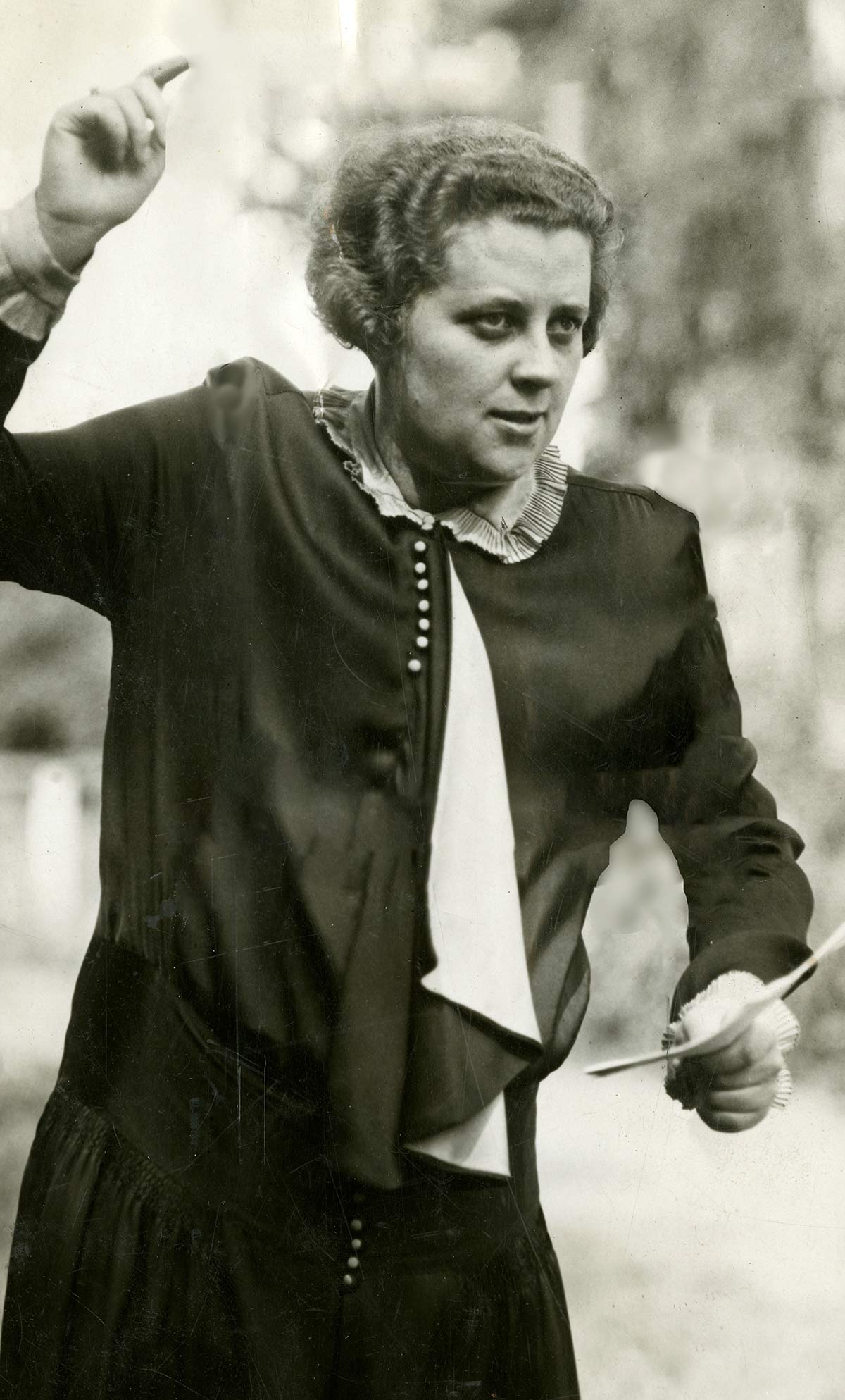 Black-and-white portrait of Helen Gwendolyn Jones gesturing with one hand raised while holding papers.