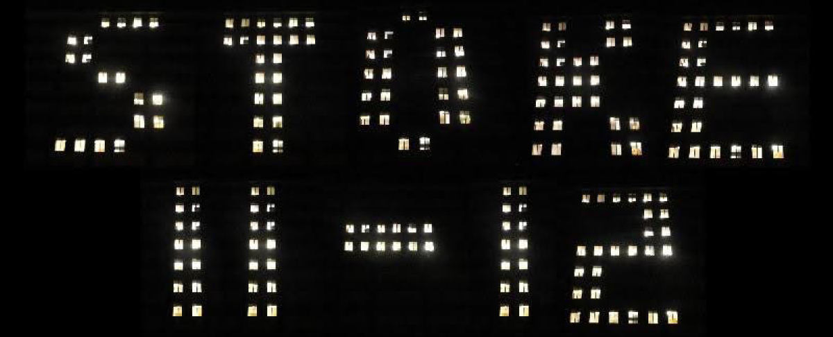 Building exterior at night with illuminated window lights spelling out "STOKE II-12".