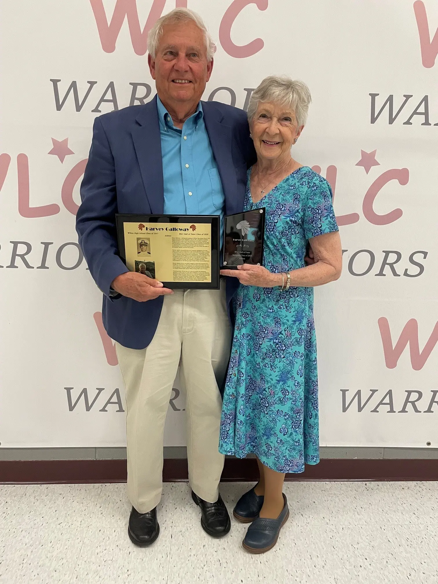 Harvey Galloway stands with his wife, Sherry, while holding a plaque and award at his Wilton High School Athletic Hall of Fame induction.