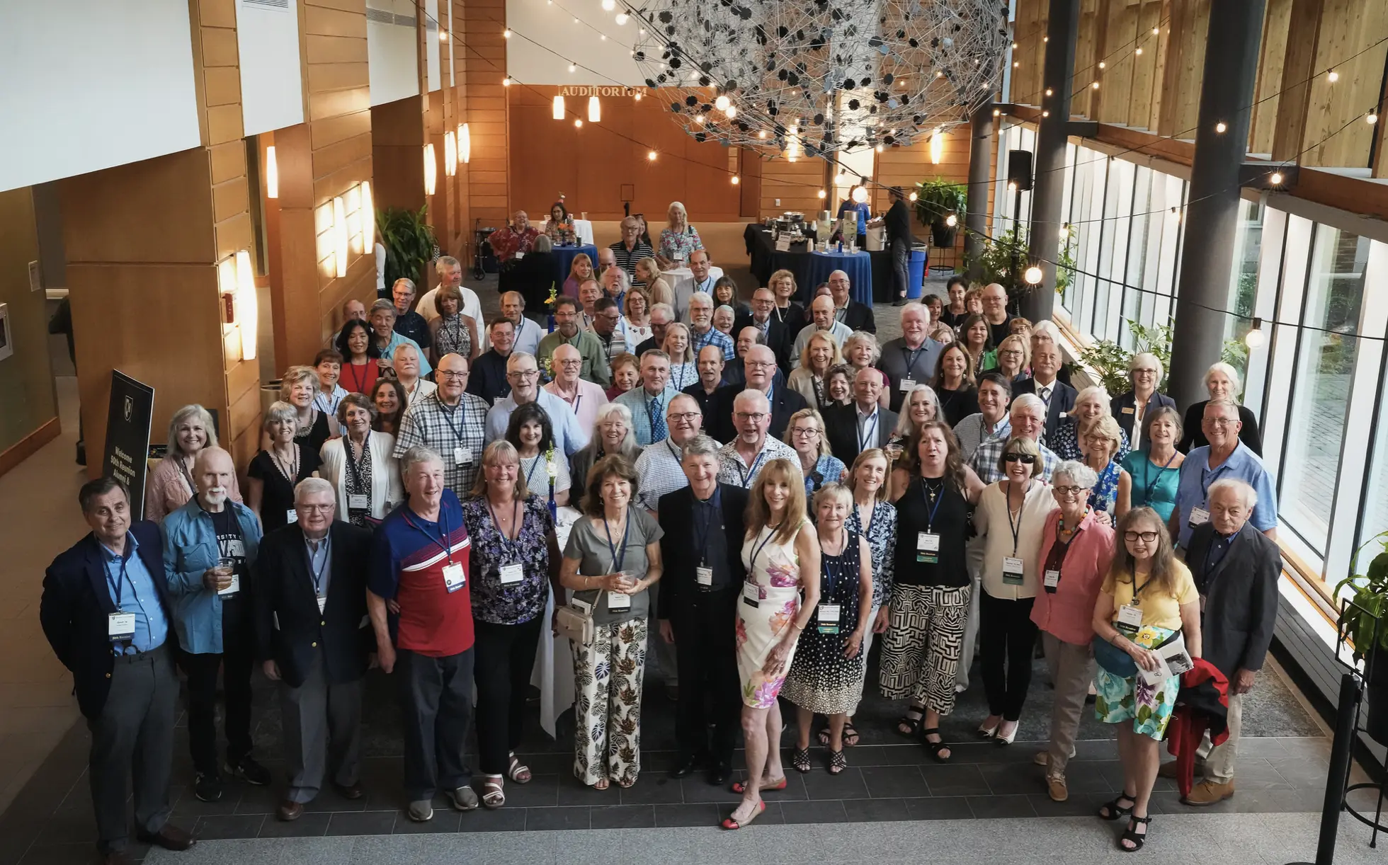 A large group of Class of 1976 alumni and friends gathers for a reunion reception.
