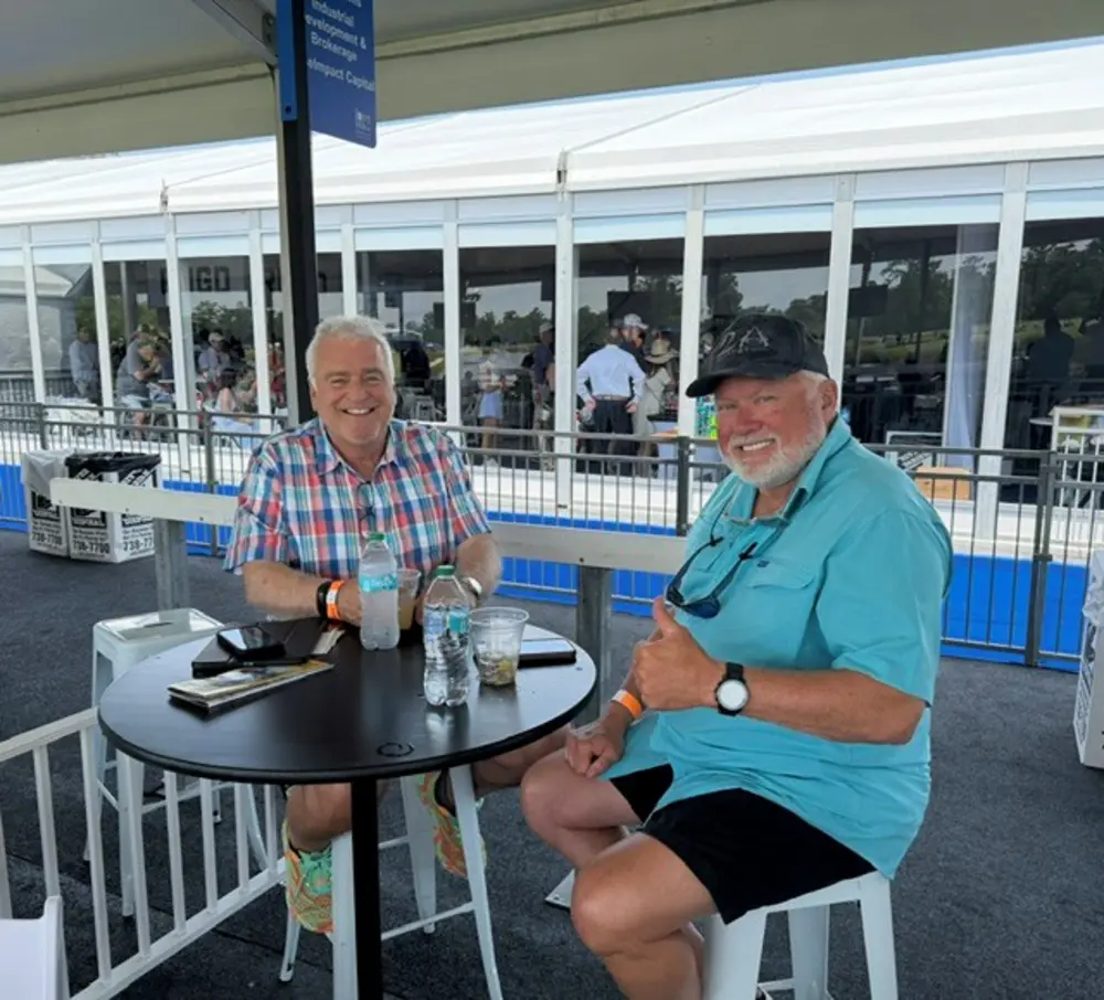 Daniel Poulin and Bruce Barnard, both Class of 1979, sit together at an outdoor table in New Orleans.