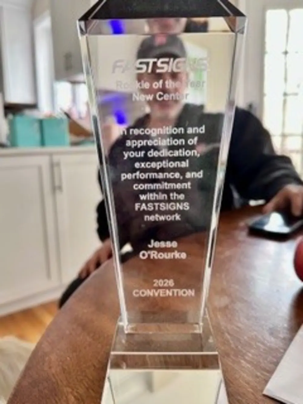 A clear FASTSIGNS award honoring Jesse O’Rourke as Rookie of the Year New Center stands on a table.