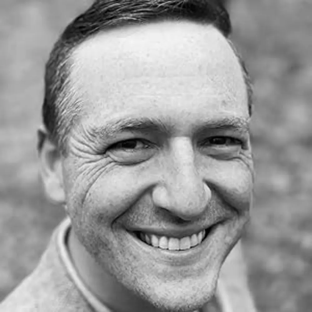 Black-and-white headshot of Jacob Goodwin ’11 smiling at the camera.