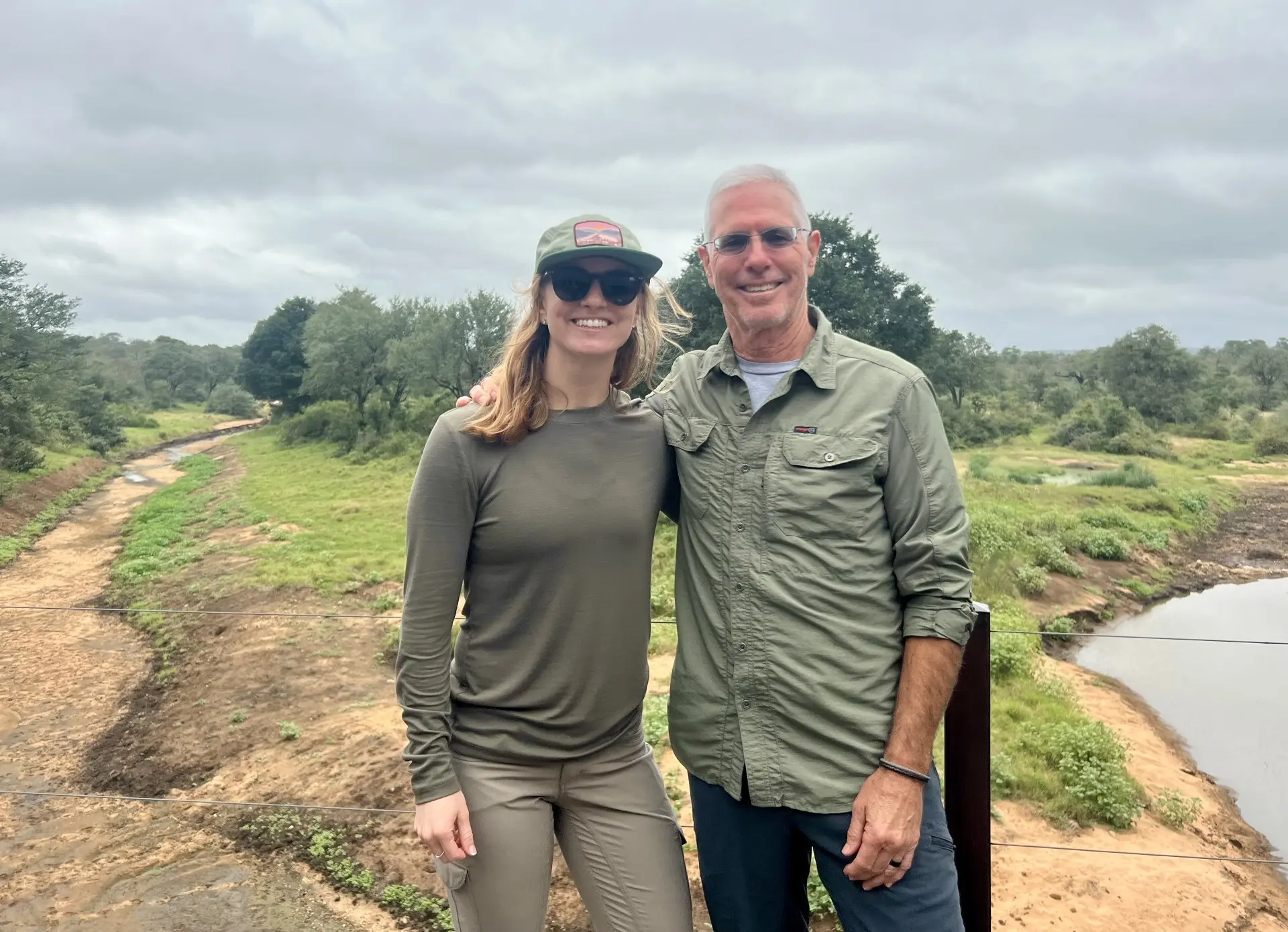 Monique LaMotte Gosselin ’13 and Tom Cruz ’85 stand together beside a river during a safari in South Africa.