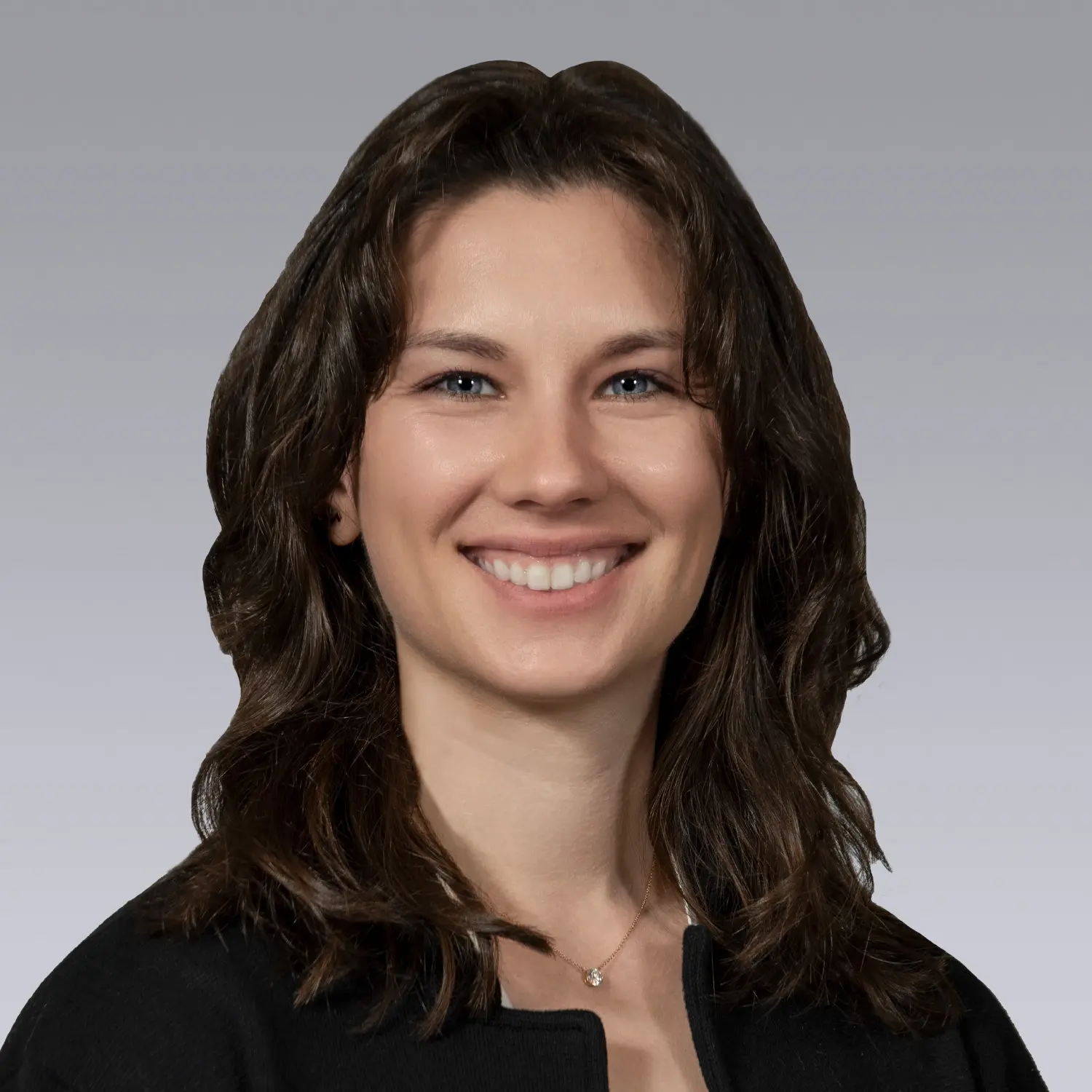 Professional headshot of Abby Bachman ’18 smiling against a gray background.